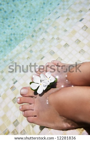 Woman feet in water at swimmingpool