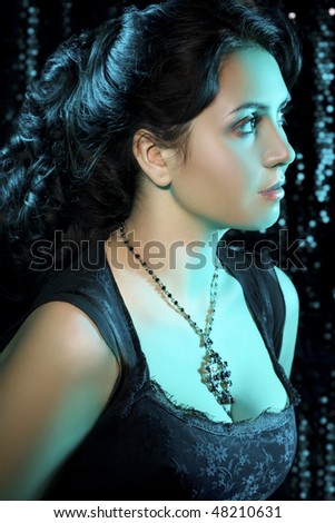Portrait of young beauty with jewelry in turquoise light