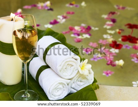Relaxing spa still life with towels. Flowers in water on background.