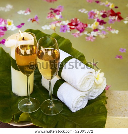 Relaxing spa still life with towels. Flowers in water on background.