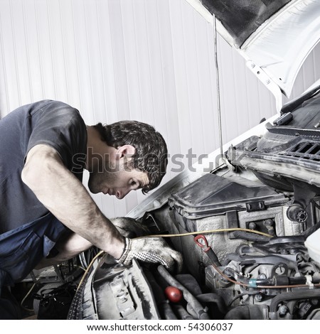 auto mechanic repairing a car engine. Space for text.