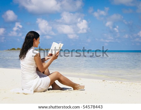 Woman reading book near the ocean