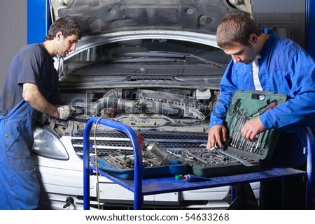 Two auto mechanics working at auto repair shop