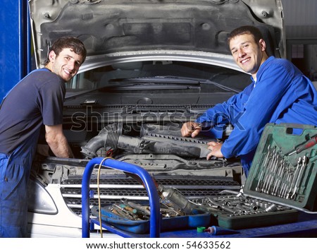 Auto mechanics near car. Different working tools on foreground