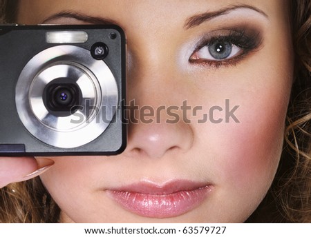 Woman with digital photo camera. Focus on face.