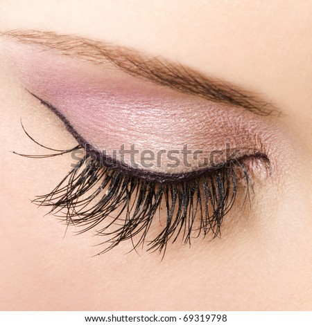 Woman eye with pastel color makeup and long eyelashes