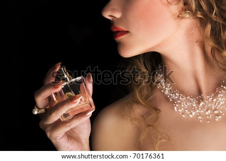 Beauty applying perfume on her neck