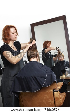 hairdresser making haircut at beauty salon