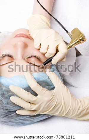 Cosmetologist making permanent makeup