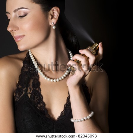 Elegant woman with perfume on black