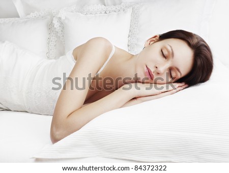 Beautiful woman sleeping on white bed linen