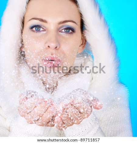 Winter girl and snow flakes. Focus on eyes.