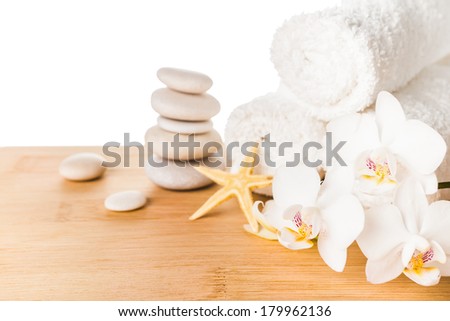 Spa concept with stacked of stones, starfish, white flowers orchid and white towels