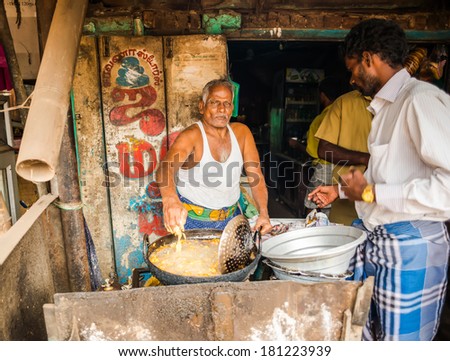 THANJAVOUR, INDIA - FEBRUARY 13: An unidentified Indian man fries in oil of national Indian food in rural cafe. India, Tamil Nadu, near Thanjavour. February 13, 2013