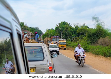 THANJAVOUR, INDIA - FEBRUARY 13: An unidentified Indian men are riding  a motorcycle at the traffic congestion rural road. India, Tamil Nadu, near Thanjavour. February 13, 2013