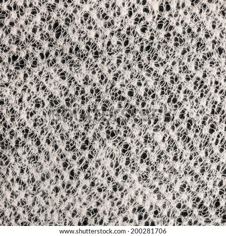texture wool knitted cloth handmade on a black background, closeup