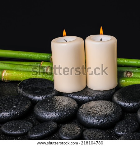 spa concept of zen basalt stones, candles and natural bamboo with dew, closeup
