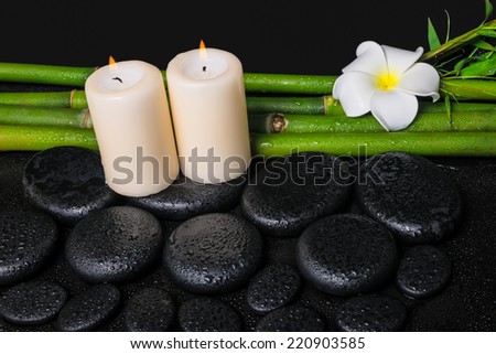 spa concept of zen basalt stones, white flower frangipani, candles and natural bamboo with dew