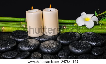 spa concept of zen basalt stones, white flower plumeria, candles and natural bamboo with dew
