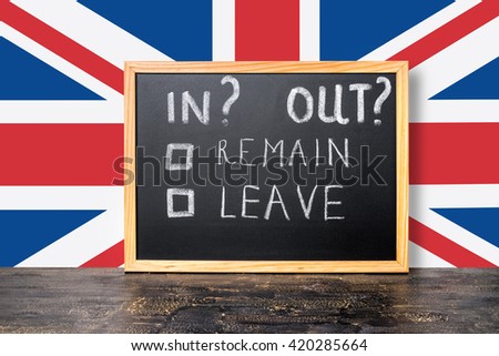 Brexit UK EU referendum concept with flag and handwriting text in, out, leave, remain is written in chalkboard, close up