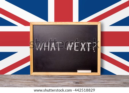 Brexit UK EU referendum concept for out of Great Britain from rest European union and handwriting text what next written in chalkboard with chalk on flag, close up