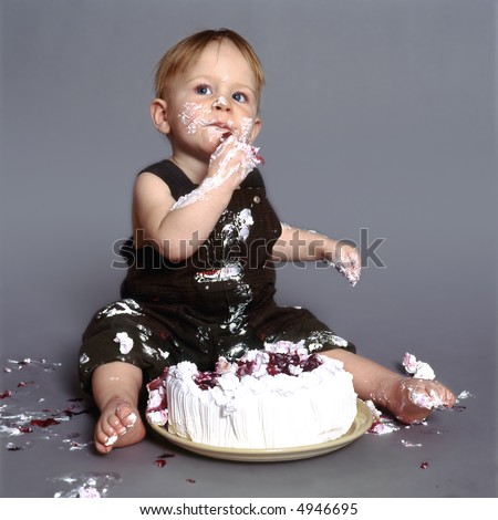 Cute little boy eating his first birthday cake