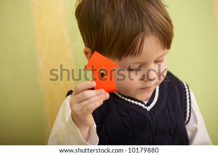 3 years old boy and little house made with color paper and scissors