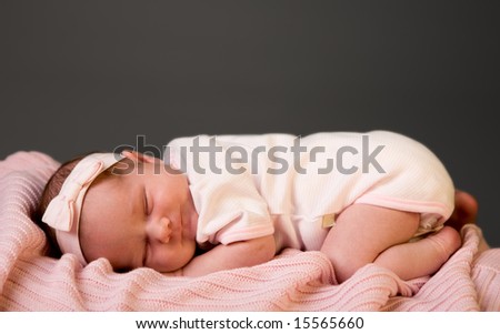 Sleeping Beauty. Studio photo of 14 days old newborn baby girl sleeping on blanket