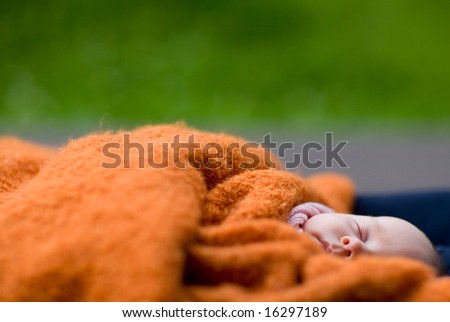 Sweet dreams outdoors. Small baby sleeps outdoors covered with warm blanket