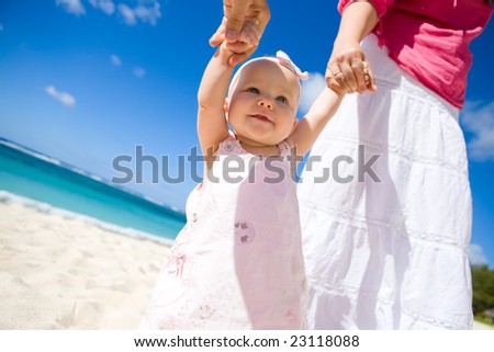 Young family with baby girl on white sand tropical beach