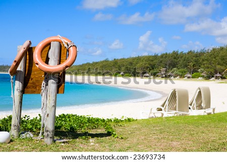 Safe swimming in paradise. Orange life buoys and white sand tropical beach.