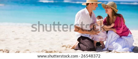 Family vacation. Panoramic photo of young family of three on white sand tropical beach