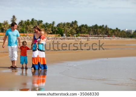 Young happy family with two kids on beach vacation
