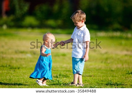 Brother and sister outdoors at sunny day