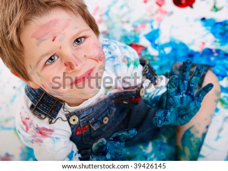 Portrait of cute 5 years old boy painting on white background