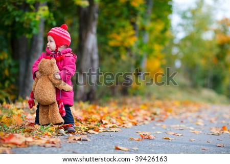 Cute 1 year old girl walking outdoors at autumn day