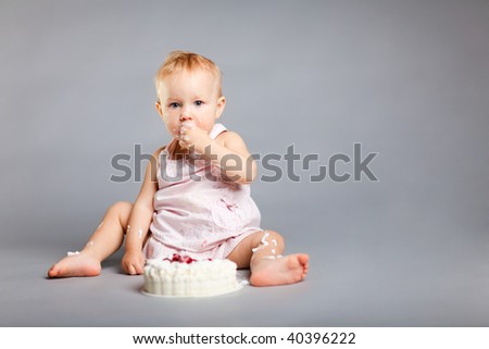 Cute little girl eating her first birthday cake