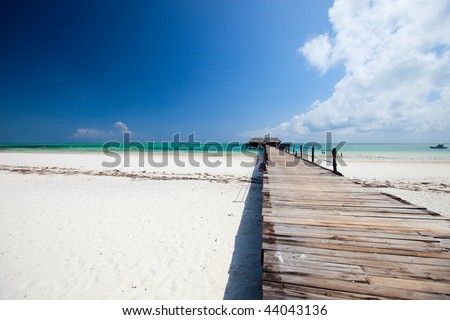 Wooden jetty on exotic beach of tropical Zanzibar island