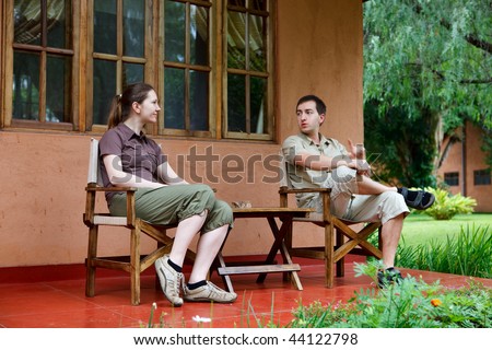 Safari vacation. Young couple in safari clothes sitting in front of their lodge room.