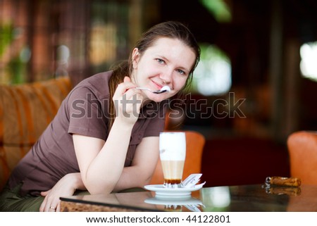 Young beautiful woman drinking latte coffee in safari lodge