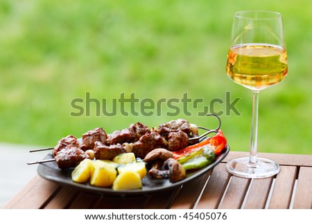 Grilling at summer weekend. Fresh grilled meat and vegetables served outdoors.