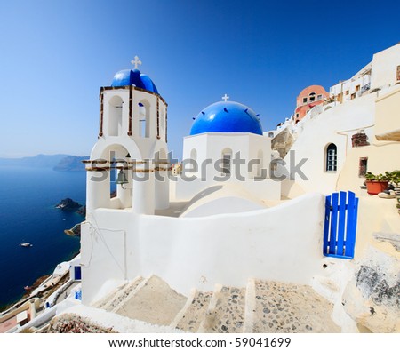 Classical greek style church in traditional white and blue Oia village in Santorini