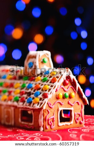 Vertical photo of gingerbread house decorated with colorful candies