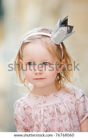 Adorable little princess with crown made from newspaper
