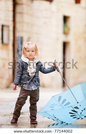 Adorable little girl outdoors on rainy day