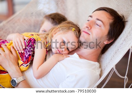 Young father and his two kids relaxing in hammock