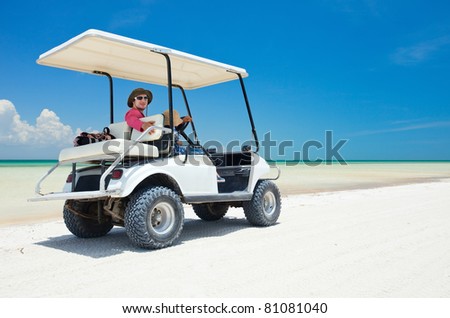 Family driving in golf cart along the tropical beach