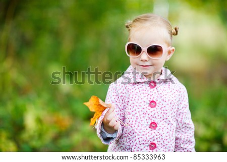 Cute little girl in a park at sunny fall day