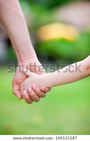 Close up of father holding his daughter hand