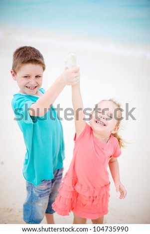 Happy brother and sister at beach having fun